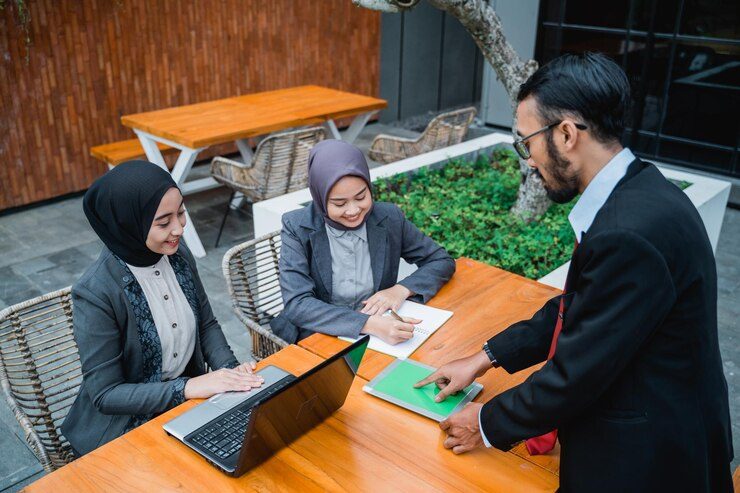 businessman-meeting-with-his-two-female-muslim-employee_8595-29772